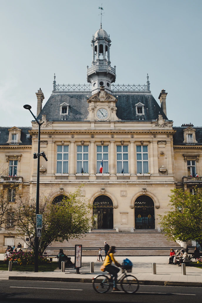Façade d’un bâtiment public, avec une horloge et le drapeau français